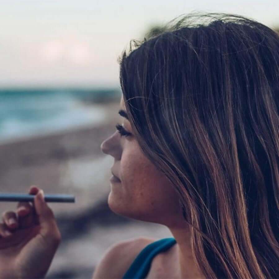 Lady holding Monq Ocean diffuser at the beach